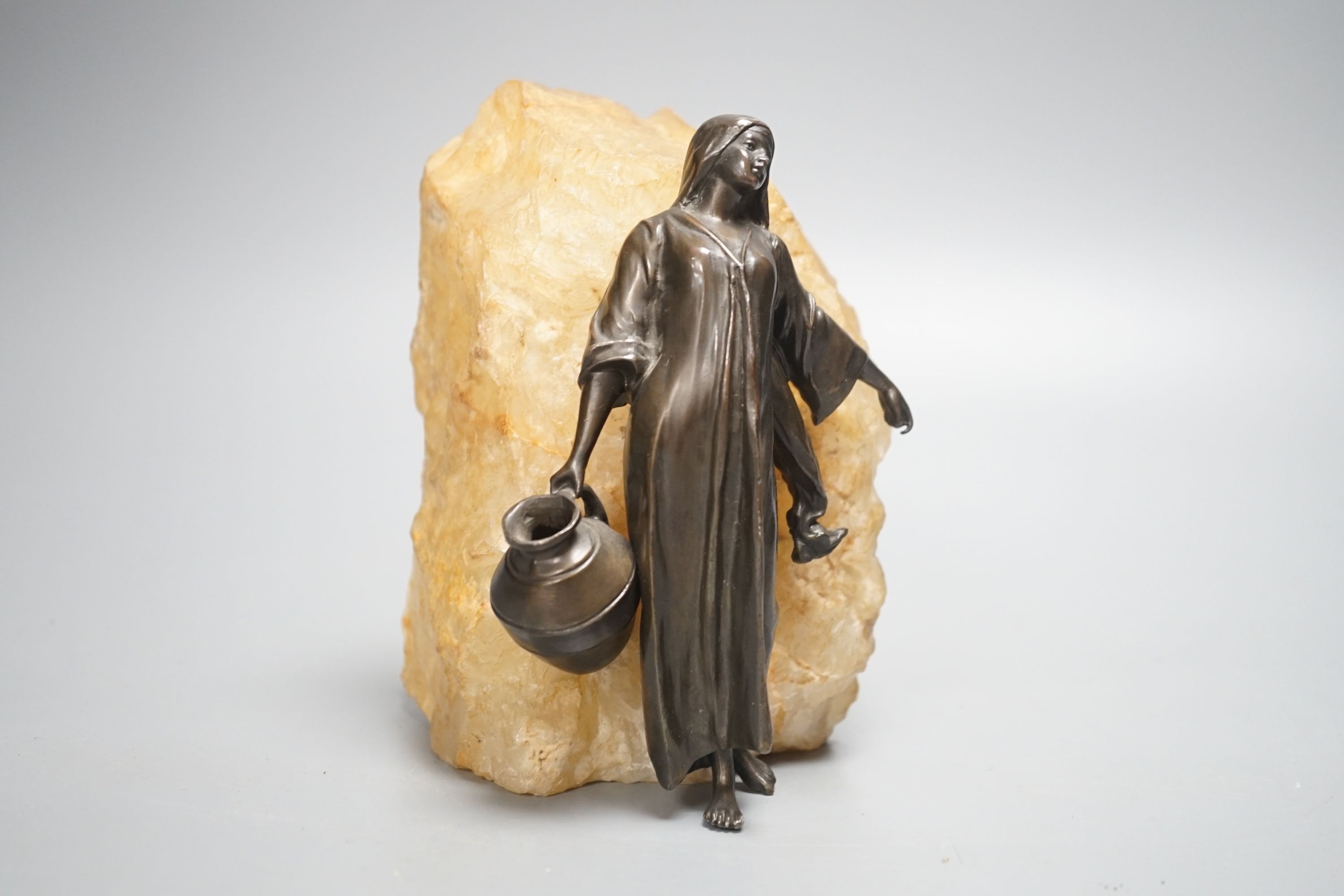 An early 20th century patinated spelter figure of a water carrier, mounted on quartz 16cm